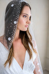 Model wears a floral wedding veil, one tier veil with pearls and fabric flowers.