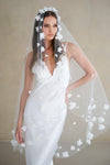 Model wears a floral wedding veil, one tier veil with fabric flowers.