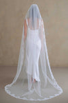 Model wears a lace wedding veil, one tier veil with lace trim.