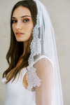 Model wears a lace wedding veil, one tier veil with lace trim.