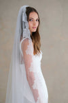 Model wears a lace wedding veil, one tier veil with lace trim.