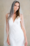 Model wears a wedding veil, one tier veil with pearls and sequins