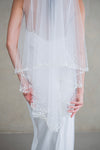 Model wears a wedding veil, drop veil with pearls and sequins