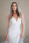 Model wears a pearl wedding veil, one tier veil with pearls.