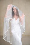 Model wears a pearl wedding veil, drop veil with pearls.