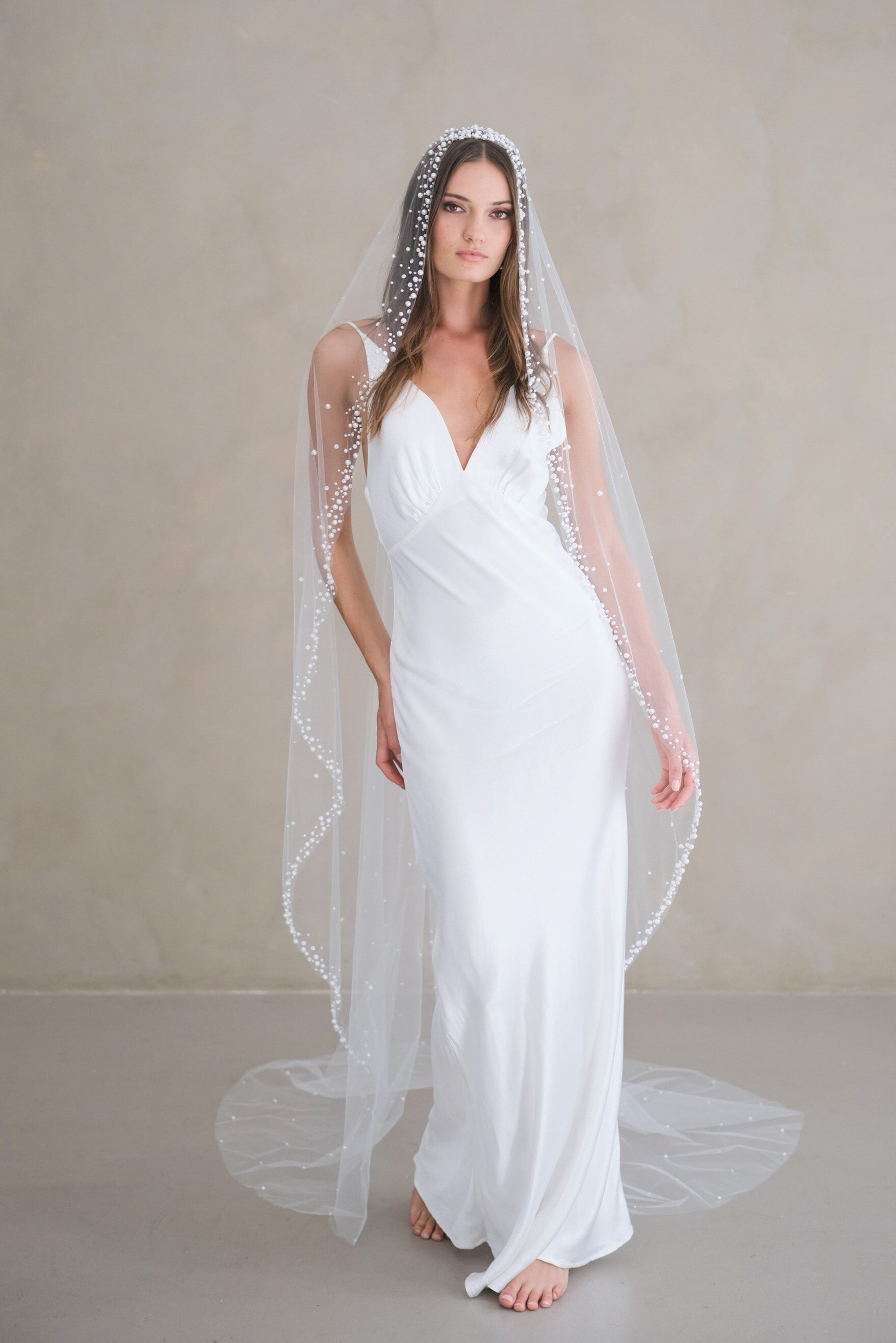 Model wears a pearls and sequins wedding veil, one tier veil