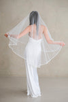 Model wears a wedding veil, drop veil with pearls and sequins