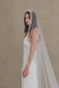 Model wears a wedding veil, one tier veil with pearls and sequins